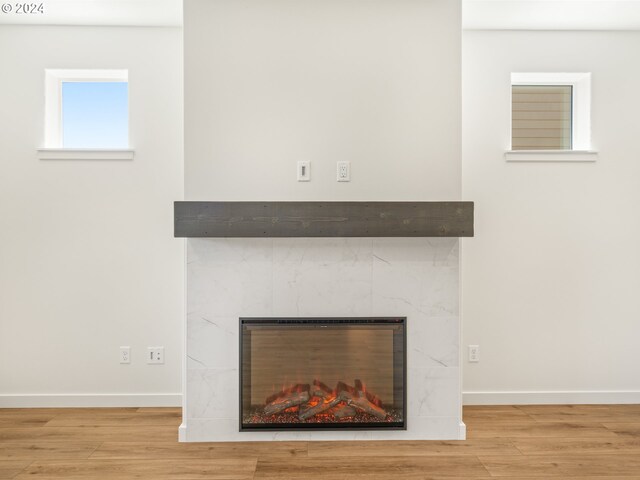 room details featuring wood-type flooring and a tile fireplace