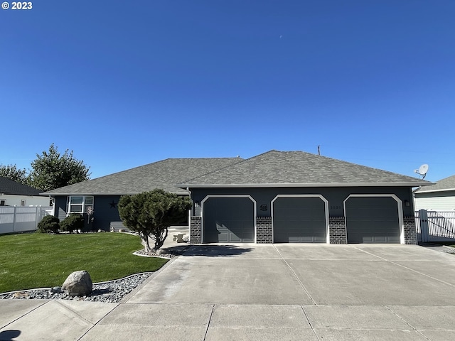 single story home featuring a front lawn and a garage