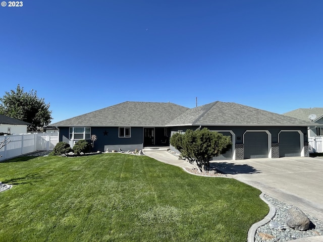 ranch-style house featuring a front yard and a garage