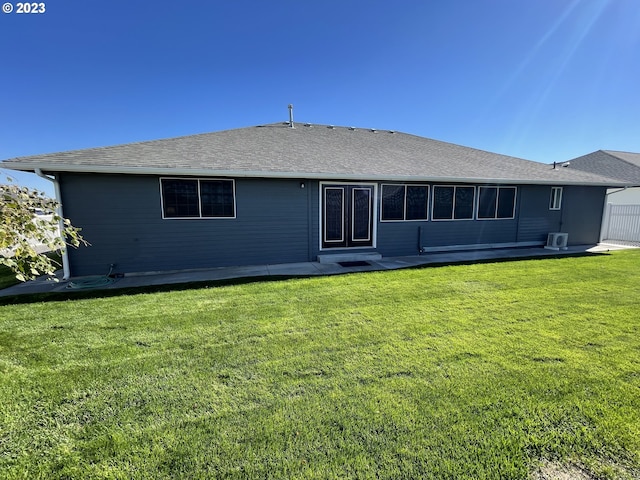 rear view of house with a patio and a yard