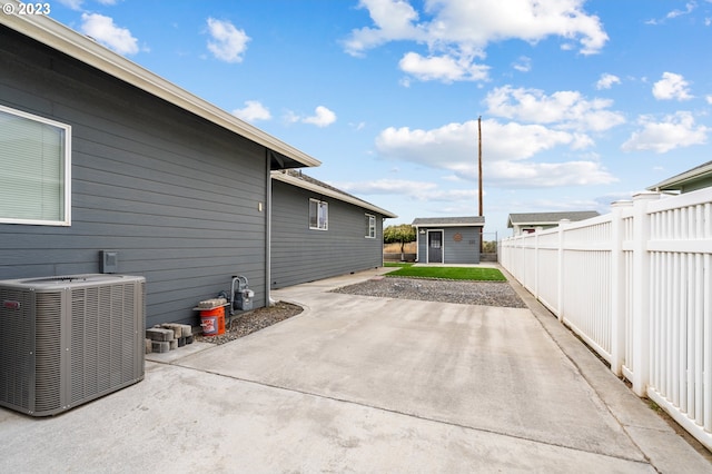 view of patio featuring central air condition unit and an outbuilding