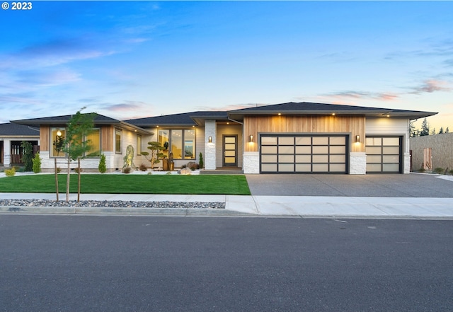 prairie-style home featuring a yard and a garage