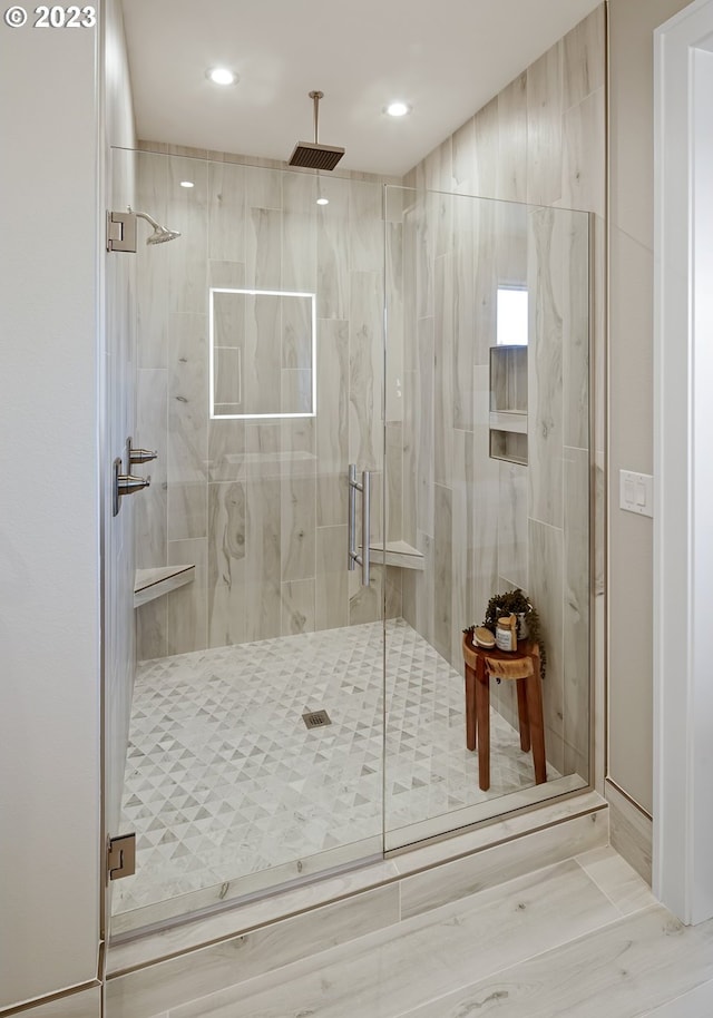 bathroom with a shower with door