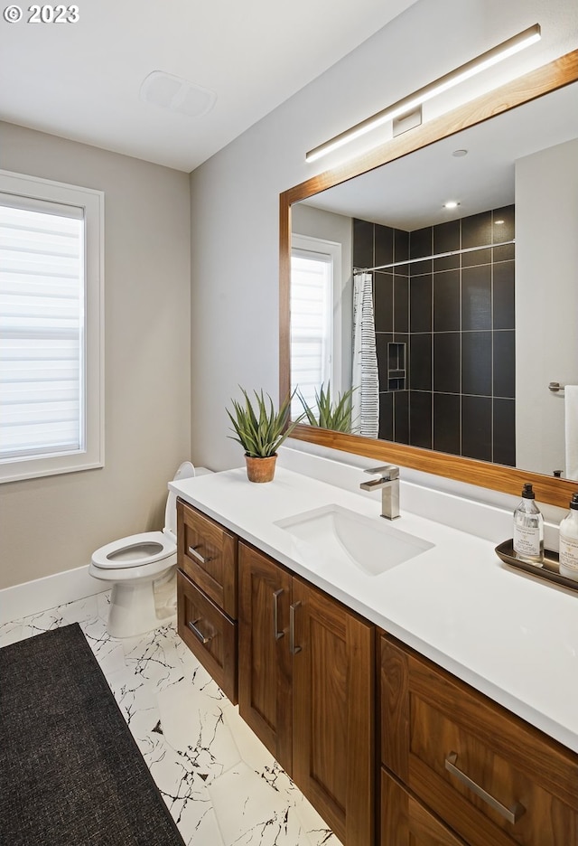 bathroom with tile flooring, toilet, and vanity