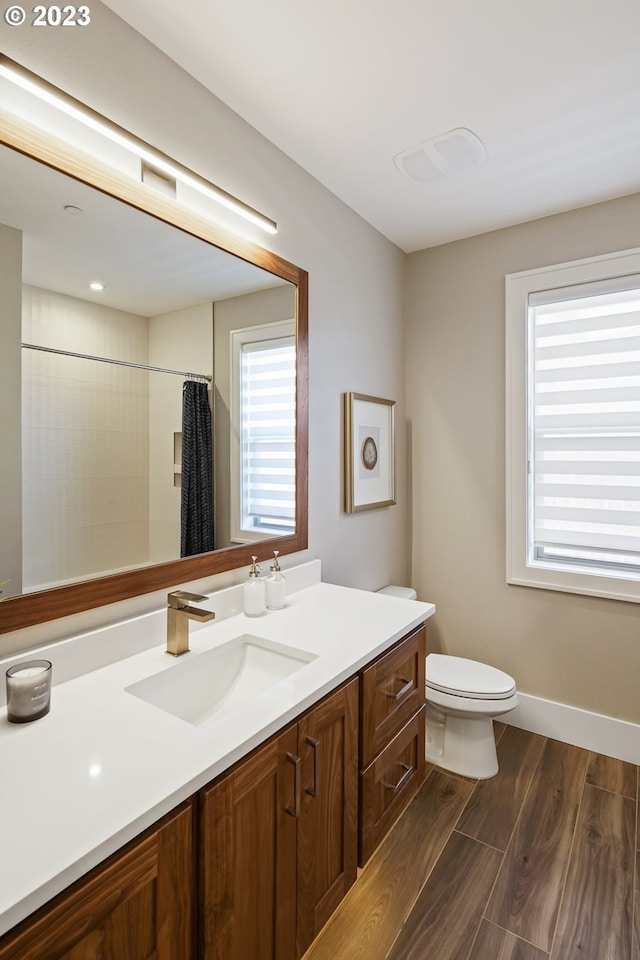 bathroom with toilet, vanity, and hardwood / wood-style flooring