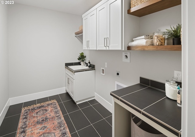 laundry room featuring sink, cabinets, electric dryer hookup, and dark tile flooring