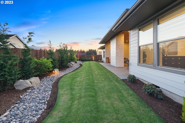 yard at dusk featuring a patio area