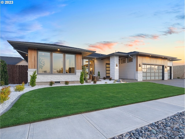 view of front of property with a garage and a yard