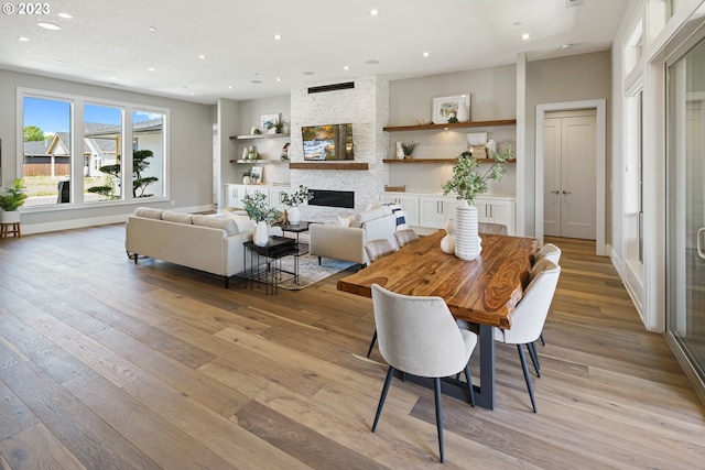 dining space featuring light hardwood / wood-style flooring and a fireplace