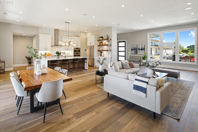 living room with a chandelier, sink, and light hardwood / wood-style flooring