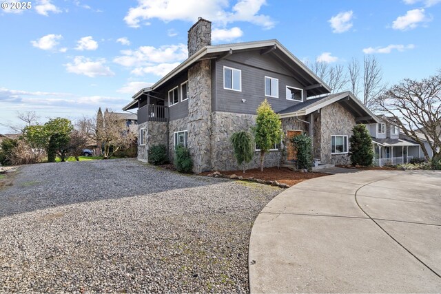 21503 NE Lachenview Ln, Fairview, OR 97024 - view of home's exterior featuring stone siding, driveway, and a chimney