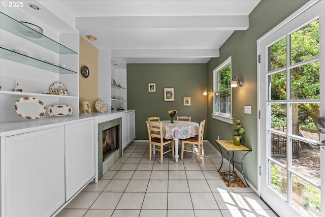5850 SW Vermont St, Portland, OR 97219 - dining space with light tile patterned floors, beamed ceiling, a tiled fireplace, and baseboards