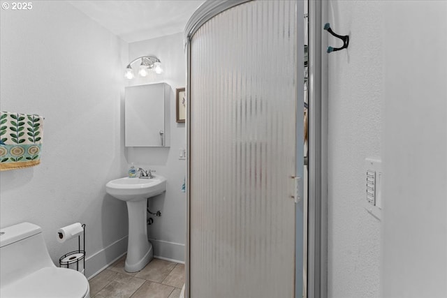 5850 SW Vermont St, Portland, OR 97219 - bathroom featuring toilet, tile patterned floors, baseboards, and a sink