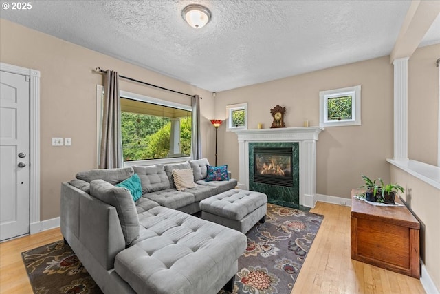 5850 SW Vermont St, Portland, OR 97219 - living area with wood finished floors, a textured ceiling, a fireplace, and baseboards