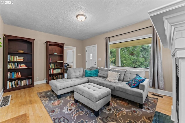 5850 SW Vermont St, Portland, OR 97219 - living room featuring wood-type flooring, a textured ceiling, and baseboards