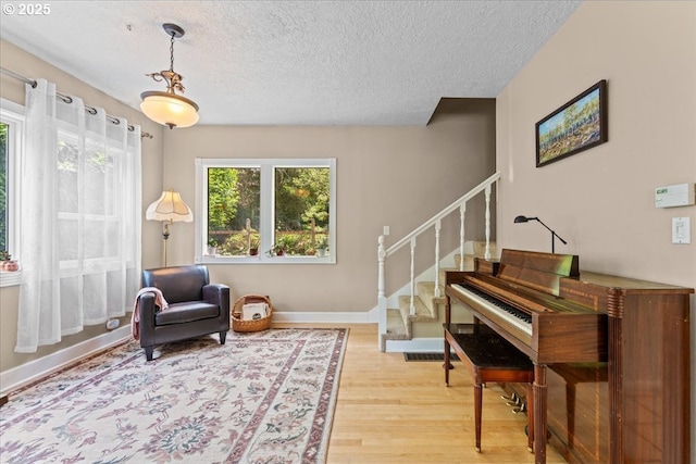 5850 SW Vermont St, Portland, OR 97219 - sitting room with light wood-style floors, stairs, a textured ceiling, and baseboards