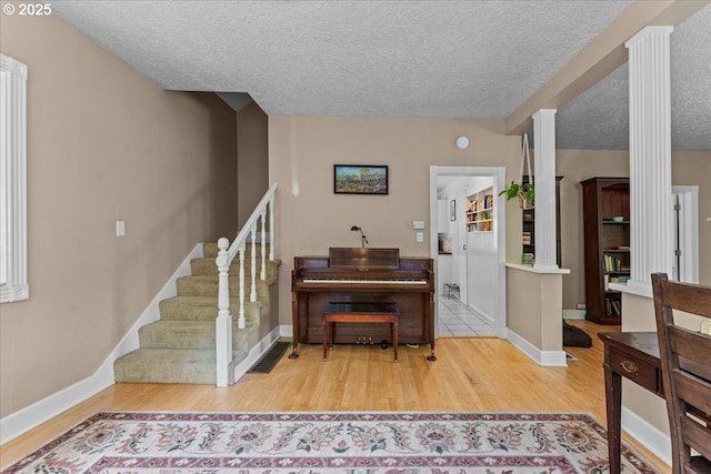 5850 SW Vermont St, Portland, OR 97219 - entrance foyer with wood finished floors, a textured ceiling, stairway, decorative columns, and baseboards