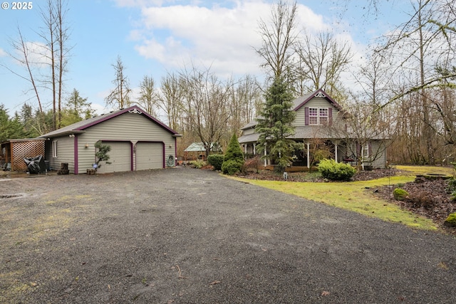 view of front of house with an outbuilding, aphalt driveway, and a garage