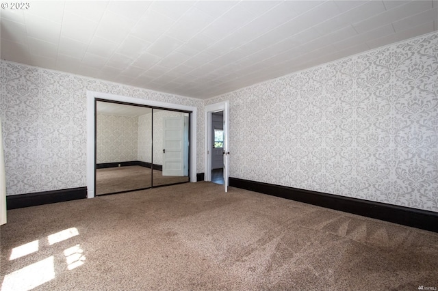 unfurnished bedroom featuring carpet flooring and a closet