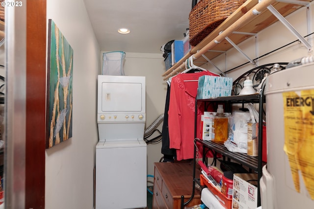 storage room featuring stacked washing maching and dryer