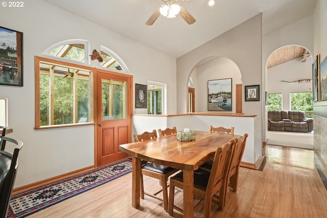 dining area with ceiling fan, light hardwood / wood-style flooring, and high vaulted ceiling