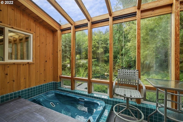 view of swimming pool featuring a skylight and an outdoor hot tub