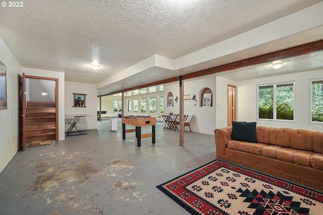 living room featuring a textured ceiling, a wealth of natural light, and concrete flooring