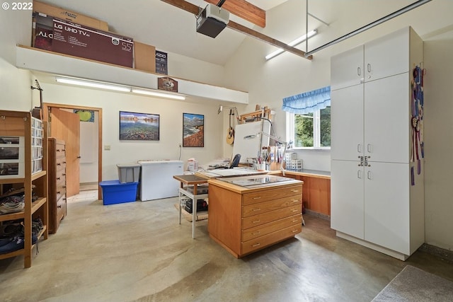 kitchen with a high ceiling, white cabinetry, and refrigerator