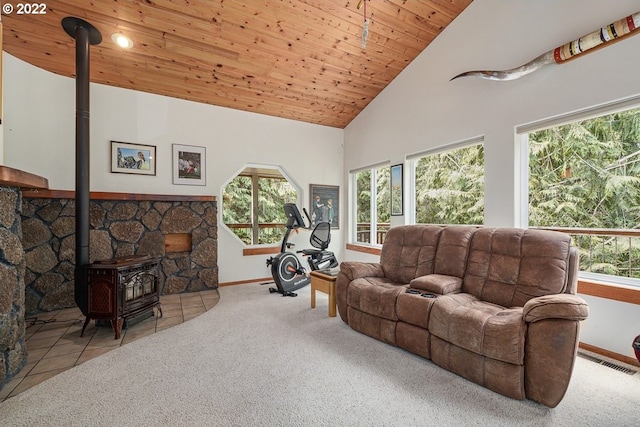 living room featuring wooden ceiling, high vaulted ceiling, a wood stove, and light colored carpet