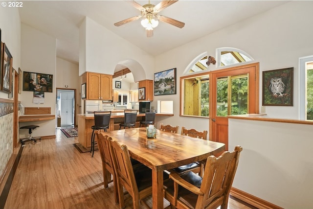 dining room featuring high vaulted ceiling, light hardwood / wood-style floors, and ceiling fan