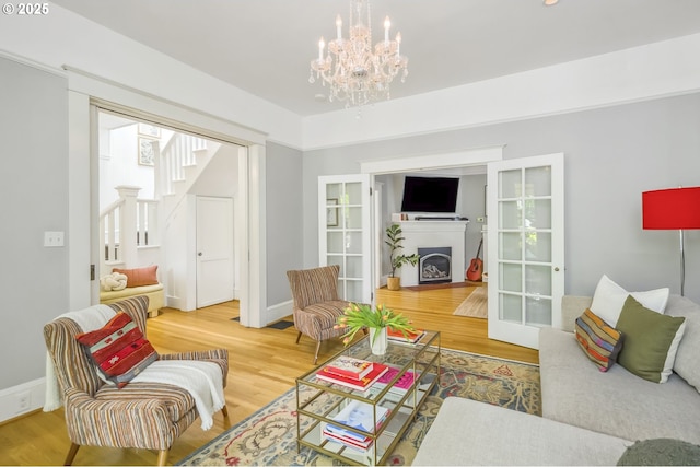 2147 NE 14th Ave, Portland, OR 97212 - living room with a fireplace, stairs, wood finished floors, and a chandelier