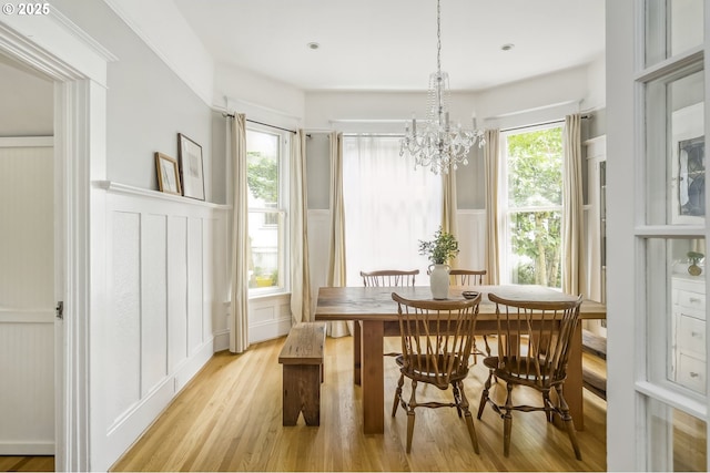 2147 NE 14th Ave, Portland, OR 97212 - dining space featuring a decorative wall, light wood finished floors, wainscoting, and a chandelier