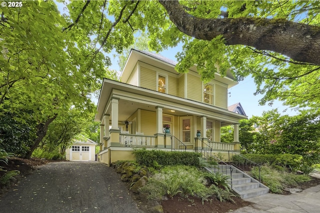 2147 NE 14th Ave, Portland, OR 97212 - view of front facade with covered porch, a detached garage, an outbuilding, and driveway