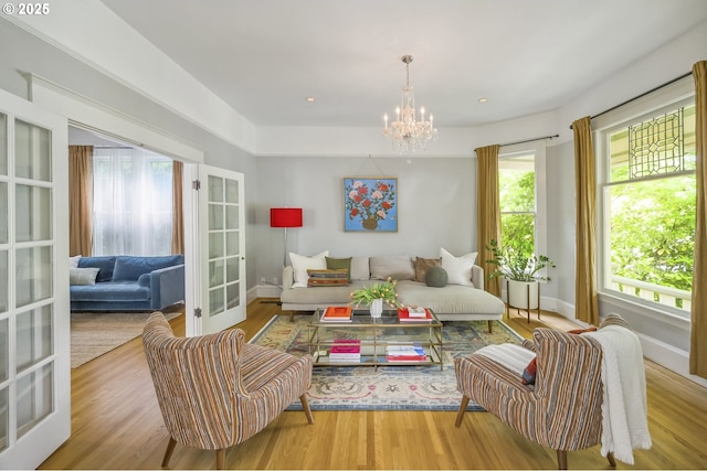 2147 NE 14th Ave, Portland, OR 97212 - living room with a chandelier, wood finished floors, french doors, and baseboards