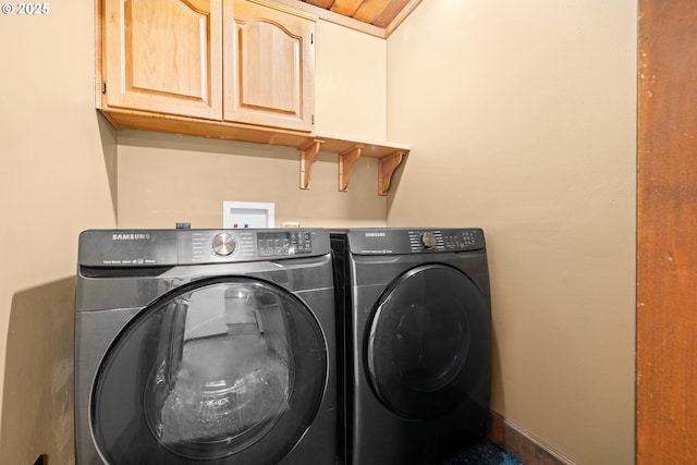 laundry room with cabinets, independent washer and dryer, and wooden ceiling