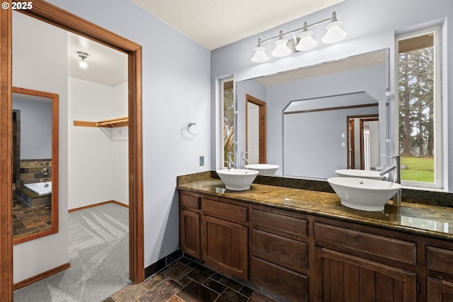 bathroom with vanity and a washtub