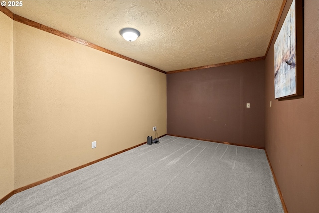 carpeted empty room featuring crown molding and a textured ceiling