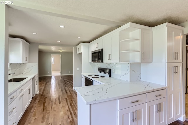 kitchen featuring white cabinets, tasteful backsplash, light stone countertops, and electric range