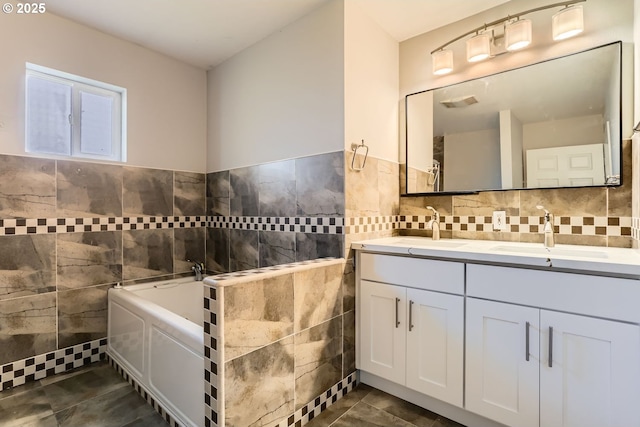 bathroom featuring tile walls, tile patterned flooring, a bathtub, and vanity