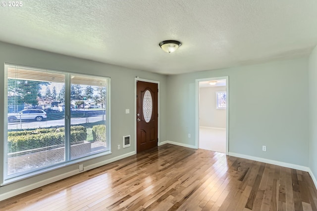 foyer with a textured ceiling and light hardwood / wood-style floors