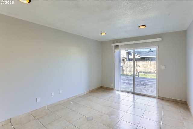 unfurnished room featuring a textured ceiling and light tile patterned floors