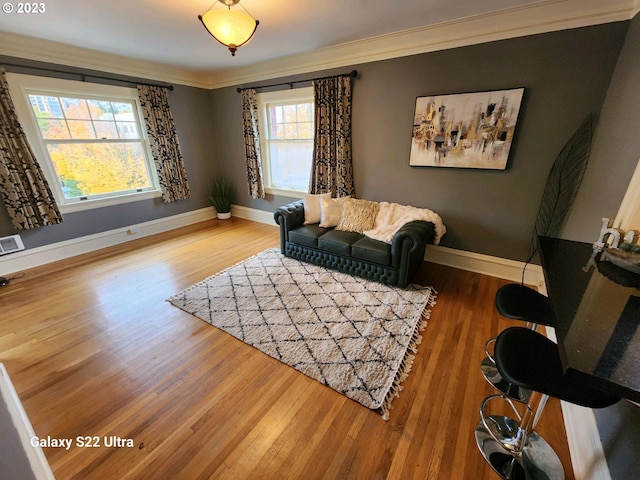 living room with crown molding, a wealth of natural light, and light wood-type flooring