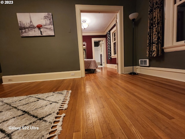 empty room featuring light wood-type flooring and crown molding