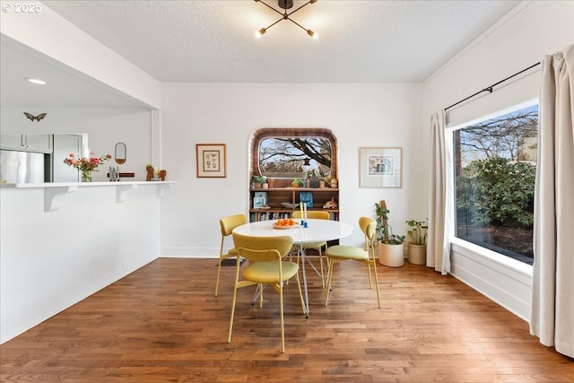 dining area with hardwood / wood-style flooring and a textured ceiling