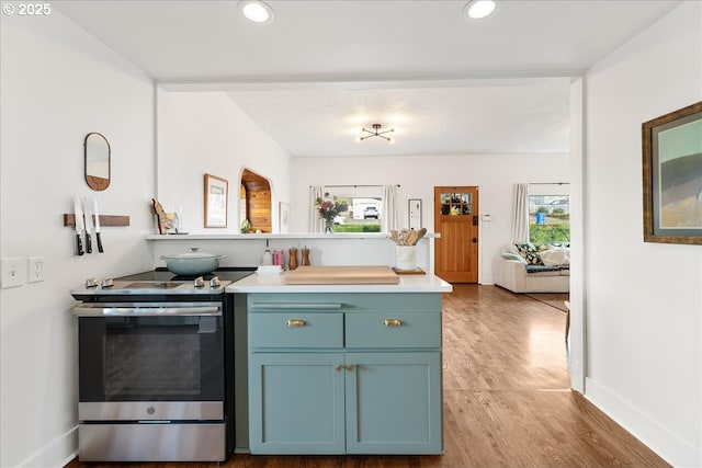 kitchen featuring electric range and light hardwood / wood-style flooring