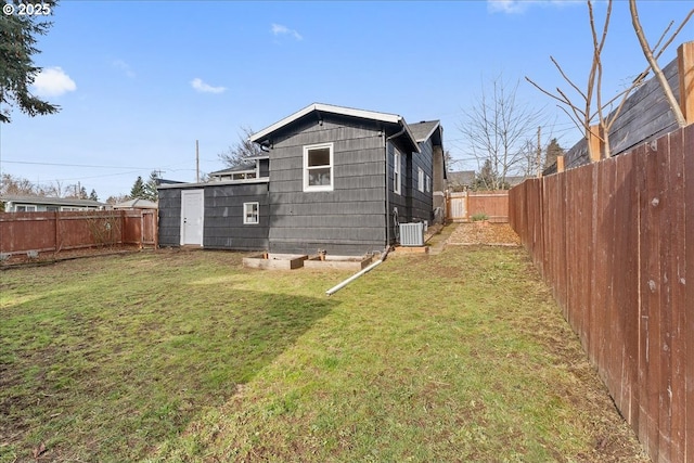 back of property featuring a lawn and central air condition unit