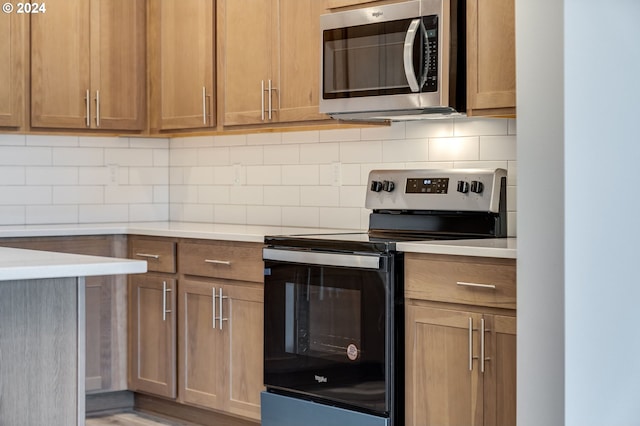 kitchen with hardwood / wood-style flooring, stainless steel appliances, and backsplash