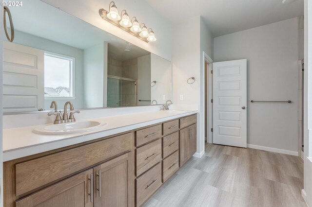 bathroom with hardwood / wood-style floors, an enclosed shower, and vanity