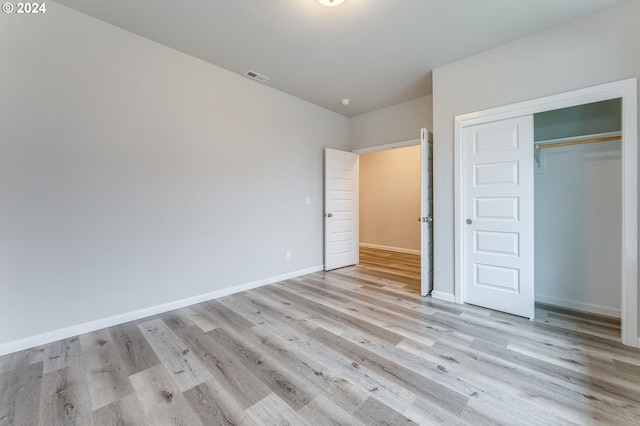 unfurnished bedroom featuring a closet and light hardwood / wood-style floors