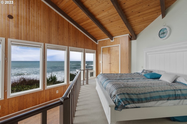 carpeted bedroom featuring a water view, wood walls, and beam ceiling